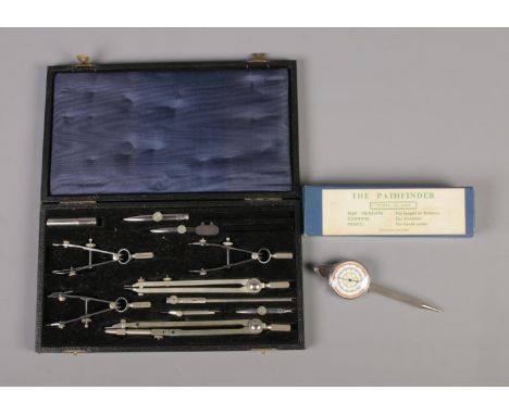 A cased 11 piece compass set and Pathfinder Three-In-One map measure, compass and pencil.  