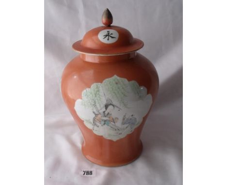 Chinese jar and cover decorated with figures on a coral coloured ground 10” high      
