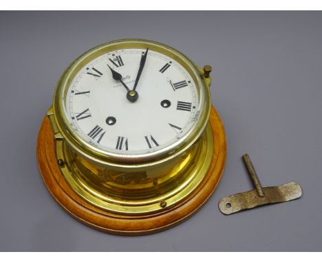 Schatz Royal Mariner brass cased bulkhead type clock, twin train movement striking the half hours on a bell, on wooden plaque