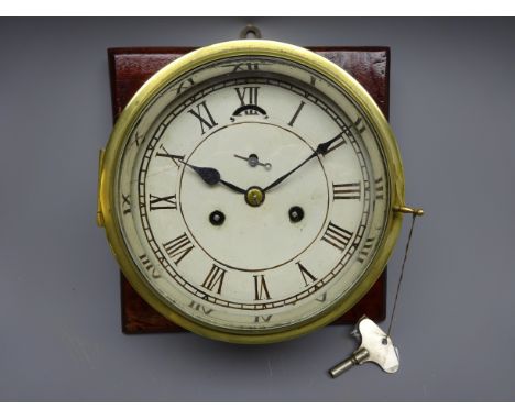 Brass bulkhead clock, painted Roman dial with subsidiary seconds and twin train movement, on mahogany mount board, D25cm max 