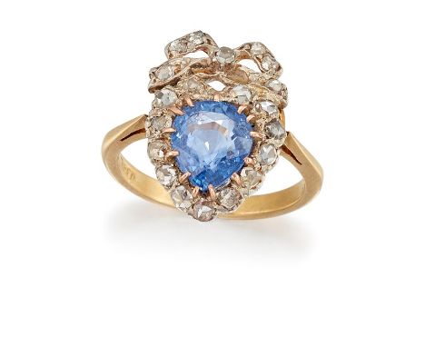 A SAPPHIRE AND DIAMOND RINGThe pear-shaped sapphire, within a heart-shaped surround with a bow surmount, set throughout with 