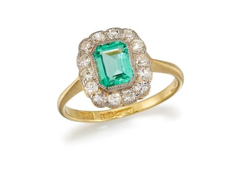 AN EMERALD AND DIAMOND CLUSTER RINGThe octagonal-cut emerald, in a single-cut diamond surround, between tapering shoulders, t