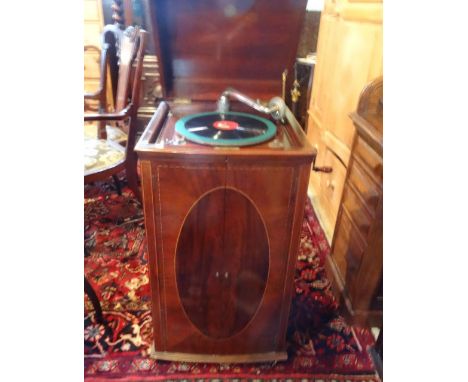 An early 20th century wine up gramophone in a mahogany and inlaid cabinet, with twin doors revealing speaker and record stora