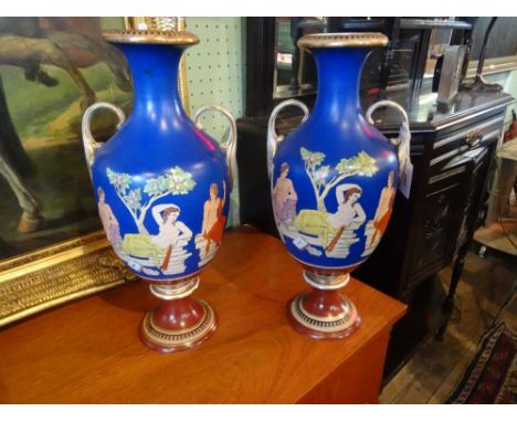 A pair of Victorian and amphora shaped vases on pedestal bases, having classical decoration on a blue ground (42.5cm). Condit