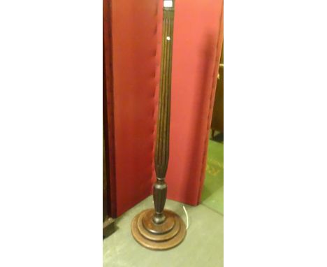 An oak standard lamp, the reeded column with acanthus leaf decoration on stepped circular foot (155cm).
