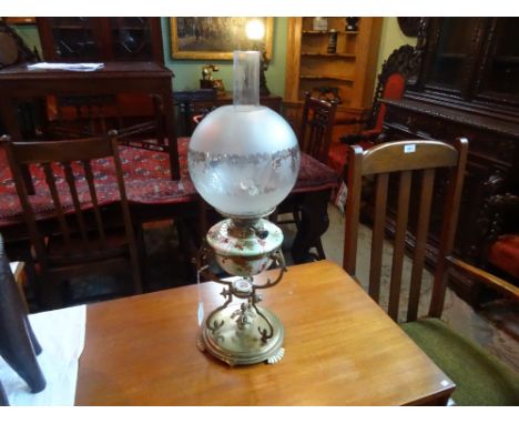 A Victorian oil lamp in the Arts & Crafts manner, the opaque green and white glass reservoir in a tri-form support on a circu