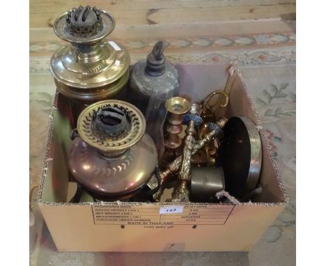 A box containing a brass and a copper oil lamp, together with accessories and other items.