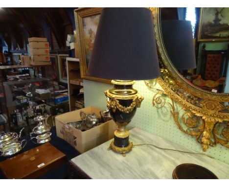 A large and decorative Regency-style table lamp, having gilt decoration throughout, to include twin rams heads, rose garlands