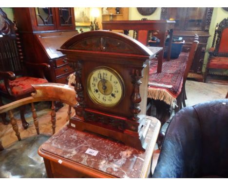 A mahogany cased mantle clock, eight day striking movement, the enamel dial bearing Arabic numerals (37cm tall).