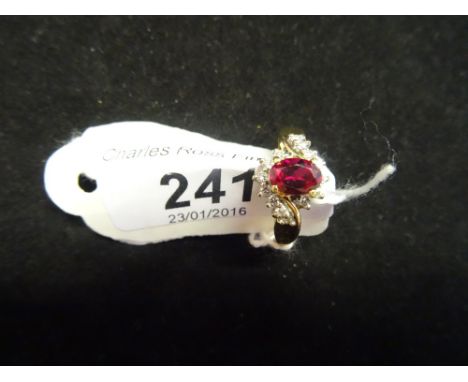 An 18ct yellow gold ring, set with oval cut ruby flanked by fourteen diamonds.