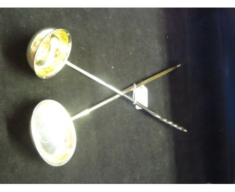 A silver toddy ladle inset with George II shilling, 1758, together with another white metal example inset with a Real coin, 1
