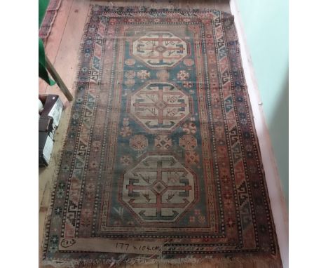 An Afghan rectangular carpet, having three octagonal lozenges, stylized floral pattern within repeating geometric border (177