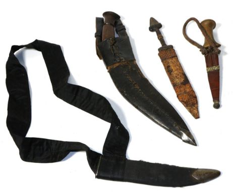 A Nepalese Kukri, with wood grip and leather scabbard; a Sudanese Arm Dagger, with wood grip and leather sheath with coiled l