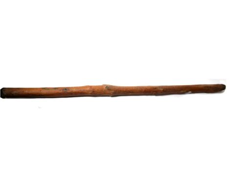 A 19th Century Australian Aboriginal Didgeridoo, of a dense red wood with chip carving to the ends, 147cm