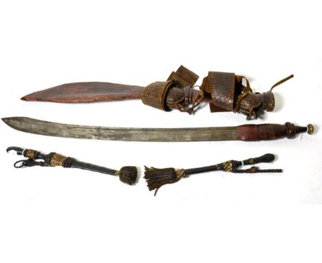 A Tuareg Sword, the 58cm single edge steel blade with two narrow fullers to the back edge and broadening at the tip, with pla