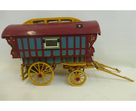 A well made brightly painted wooden model of a Romany caravan.