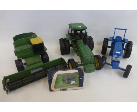 An assortment of farm die-cast models including a John Deere turbo combine, an Ertl John Deere tractor and an Ertl Ford 7710 