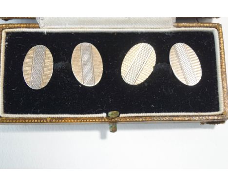 A pair of gold on silver Cufflinks, circa 1935, the oval engine turned panels in two colours, chain link connectors, cased