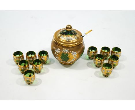 A Bohemian gilded green glass punch bowl, ladle and twelve cups, with allover raised flower decoration