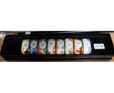 A BOXED COLLECTION OF EIGHT REPRODUCTION CLARICE CLIFF DESIGN PORCELAIN NAPKIN RINGS 