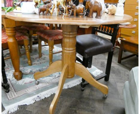 A modern light wood circular kitchen table with drop down leaves 