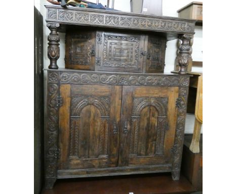 A carved oak Victorian style court cupboard with arcaded panel doors under 