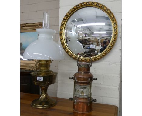 A copper ships lamp and a brass oil lamp with opaque glass shade, together with a convex circular wall mirror 