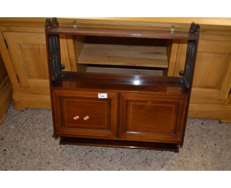 An Edwardian mahogany hanging wall shelf with cupboard base