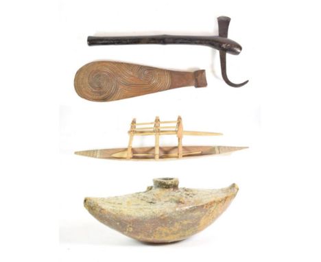 A Fijian Pottery Water Vessel, of canoe shape, glazed with makadre gum from the Dakua Pine, 24cm; a Luguru Tooling Axe, Tanza