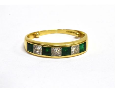 A MODERN 18CT GOLD, EMERALD AND DIAMOND SEVEN STONE HALF ETERNITY RING  the four square step-cut emeralds spaced by princess 