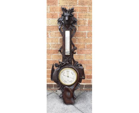 A BLACK FOREST BAROMETER/THERMOMETER BY DOLLOND  the carved oak frame incorporating oak leaves, a hunting horn and a rifle, s
