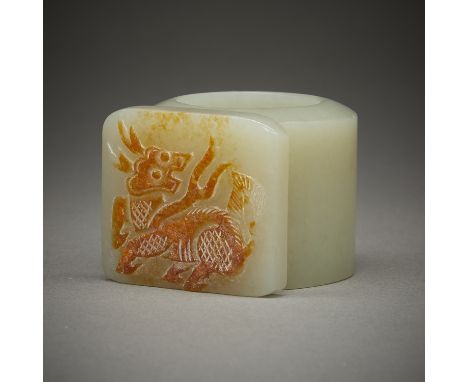 Chinese carved jade archer's ring. Well-carved with a plaque depicting a mythical beast formed from a russet inclusion.Height