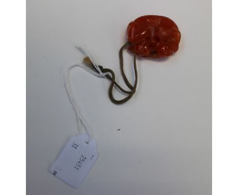 A Chinese red jade carved pendant of a monkey