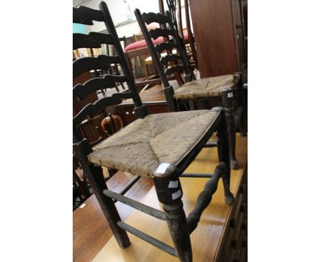 A set of four ash ladder back chairs, fitted with rush seats, (4)