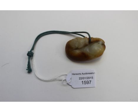 A Chinese pebble carved netsuke, Ming or Qing dynasty, conceived as a recumbent horse nibbling it's back leg, with white with