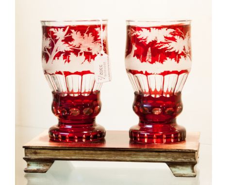 A pair of Bohemian ruby flashed tumblers, probably German, circa 1885, etched with deer in landscape, on hardwood stand
