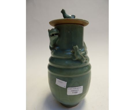 A Chinese Celadon green lidded vase, the top with a dragon in relief and a a small cat to opposite side, the green glaze on a