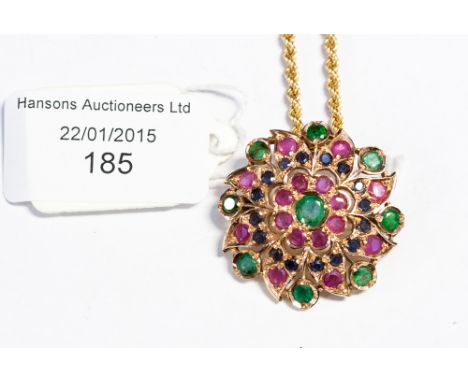 An Indian emerald, sapphire and ruby pendant/brooch, of stylised floral openwork circular shape, set central round emerald, w