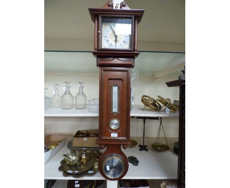 A contemporary wall clock, barometer, dry/damp gauge and thermometer, all combined in one wall hanging 