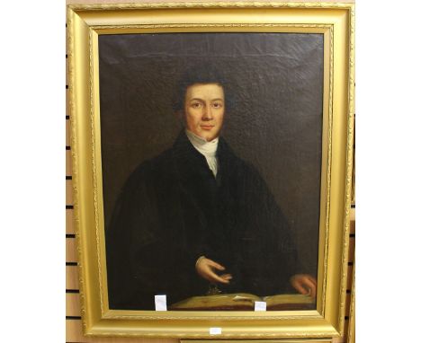 Early 19th century school, half length portrait of a young gentleman with a book, with one hand on the book and the other han