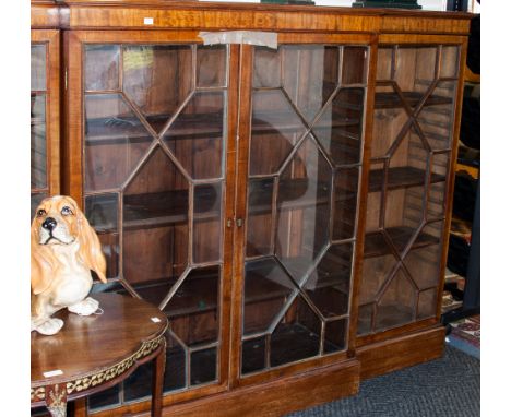 An early 20th century mahogany breakfront standing bookcase, with astragal glazed doors, enclosing four shelf tiers, on plint