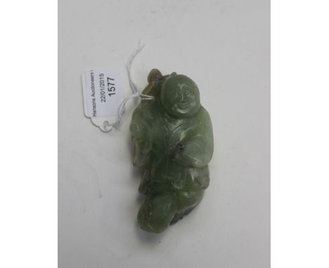 Jade like hardstone carving of a boy, shouldering a lotus, the whole with a grey green crystalline structure, 9cm long