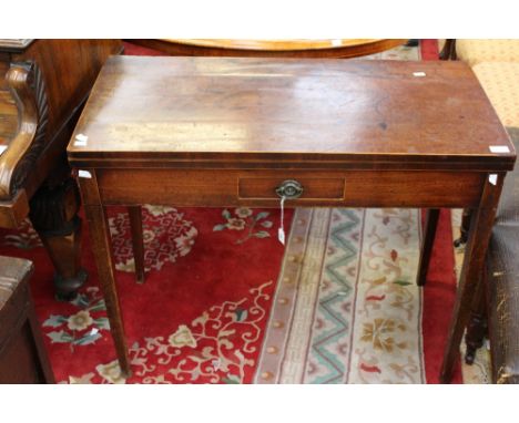 A George III mahogany card table, circa 1780, the top with boxwood edging, folding out and supported by a folding back leg, t