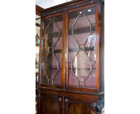 A Chippendale style mahogany bookcase, hinged astragal doors, revealing three shelf tiers and cupboard base
