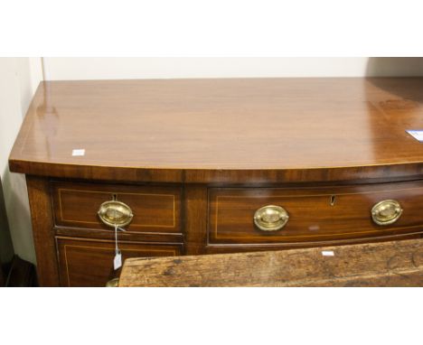 A George III mahogany sideboard, of bow-fronted form, circa 1815, fitted with a central drawer over a sliding shelf below and