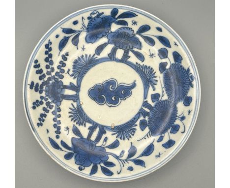 A small Chinese Wanli period blue and white porcelain shallow bowl decorated with a central cloud surrounded by flowers, 16.5