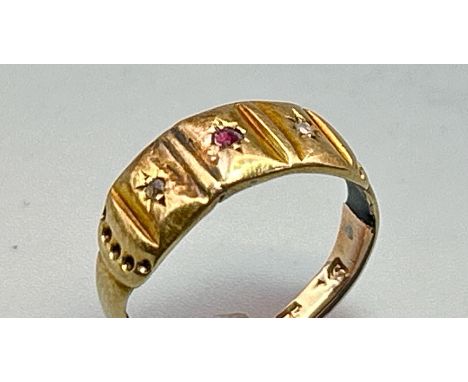 A band ring set with two rose cut diamonds and a central ruby, with a shank stamped 9ct bearing signs of internal repair poss