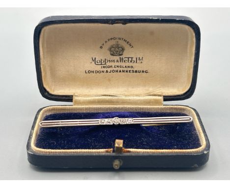 A bar brooch centrally set with five old cut diamonds, estimated total diamond weight 0.20ct, stamped 18ct, length 6.8cm, gro