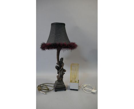 A vintage acrylic block light with a drilled hand in the centre along with a gilded moulded lamp of a faun sitting on the bac