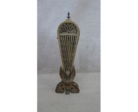 A vintage brass peacock style fireguard with nine fan tail sections standing on winged dragon base. H.61cm 